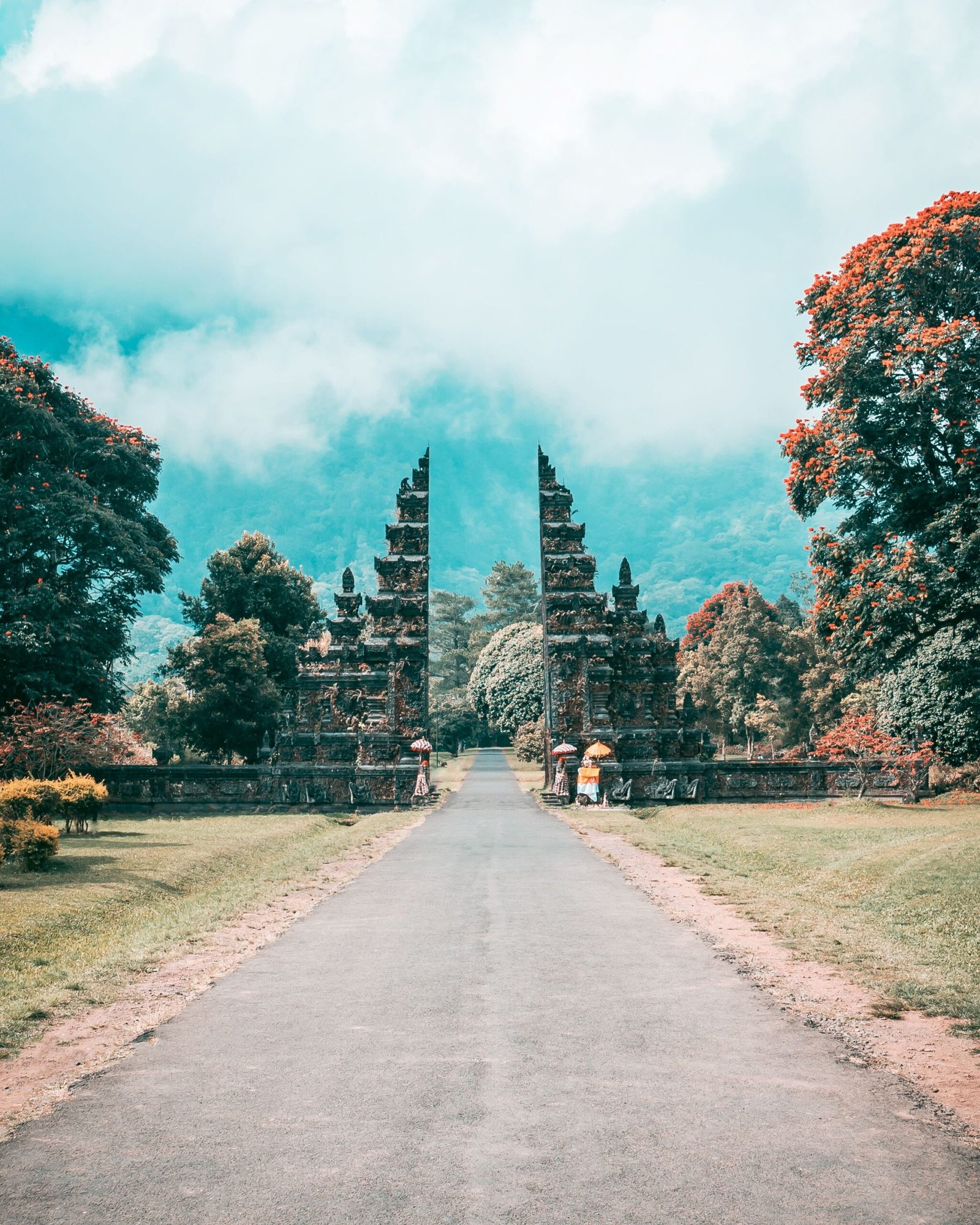 The twin stone Handara Gate framing a road into the misty hills of northern Bali